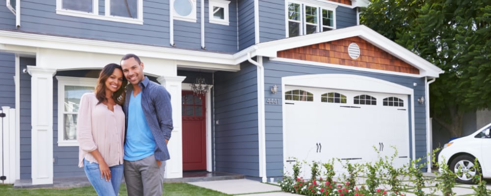 Happy couple in front of their newly constructed home.