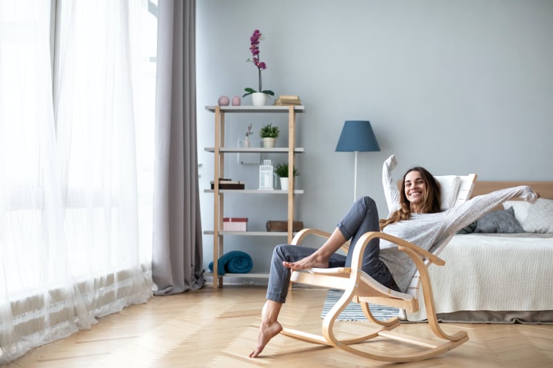 Happy woman rocking in chair in her new remodeled home.