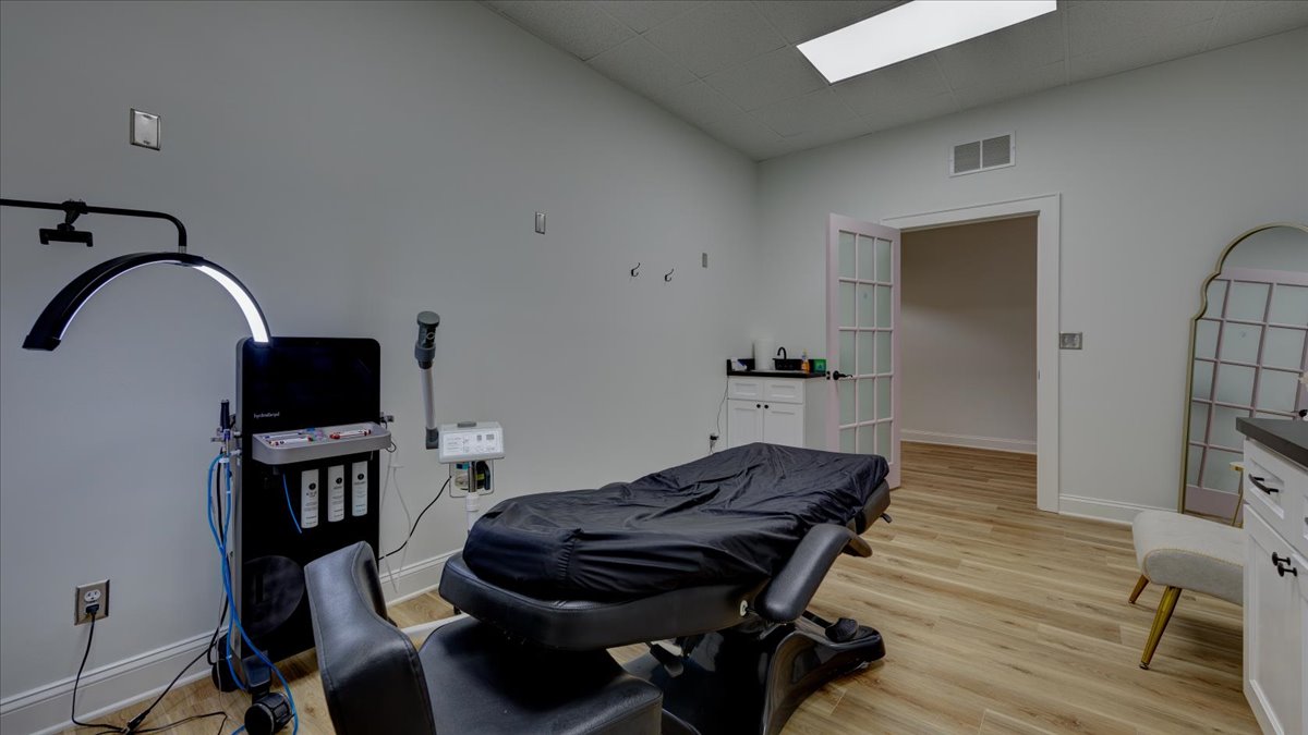 A dental exam room with a laid back black chair and equipment.