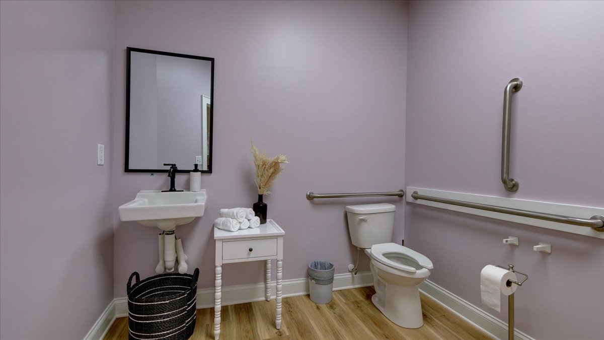 A dental office bathroom with light pink walls.