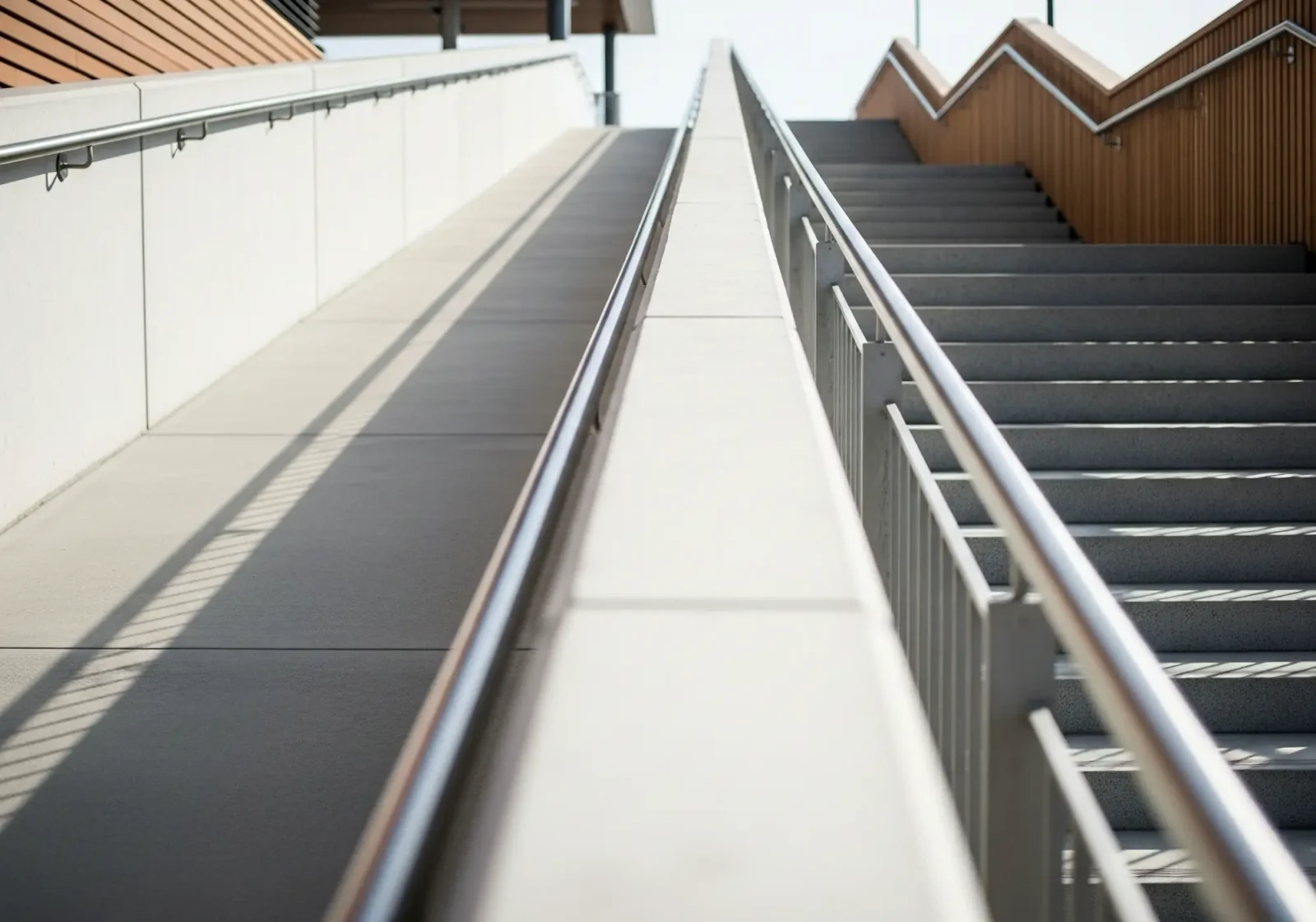 A set of three story concrete stairs with an accessible ramp.