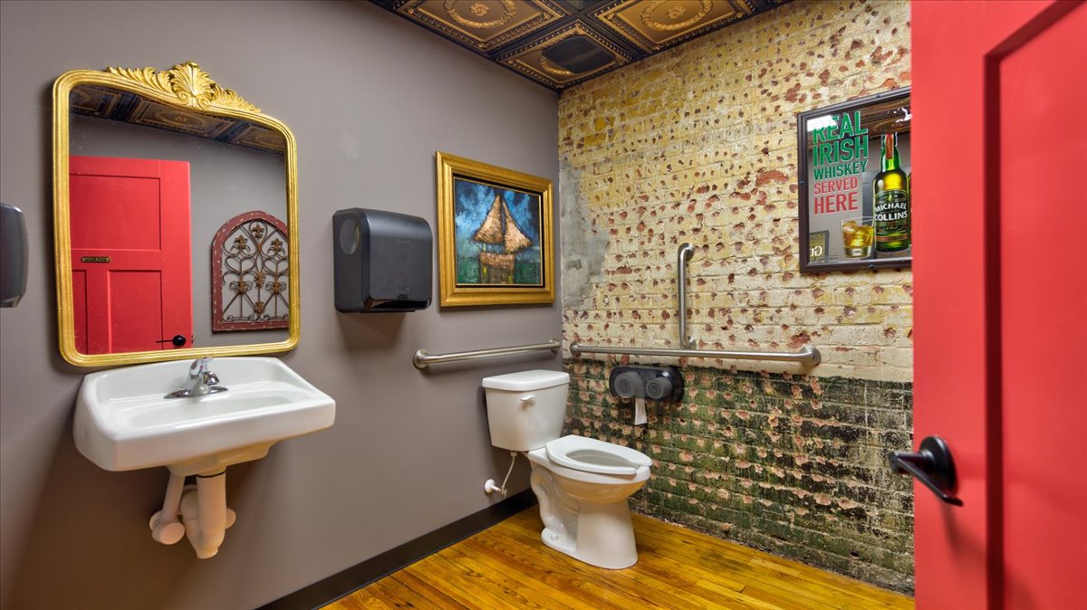 A bar bathroom with brick walls and decor.