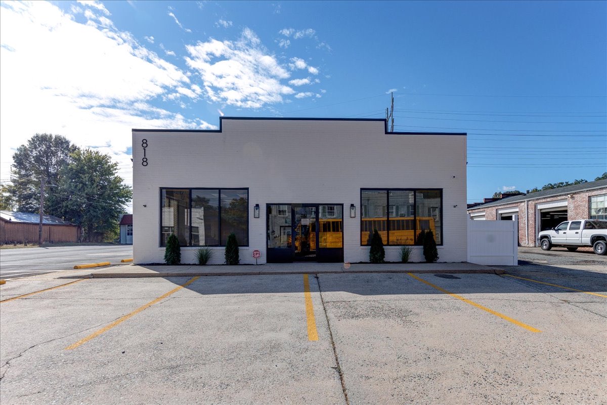 White brick exterior with black windows and doors of an office.