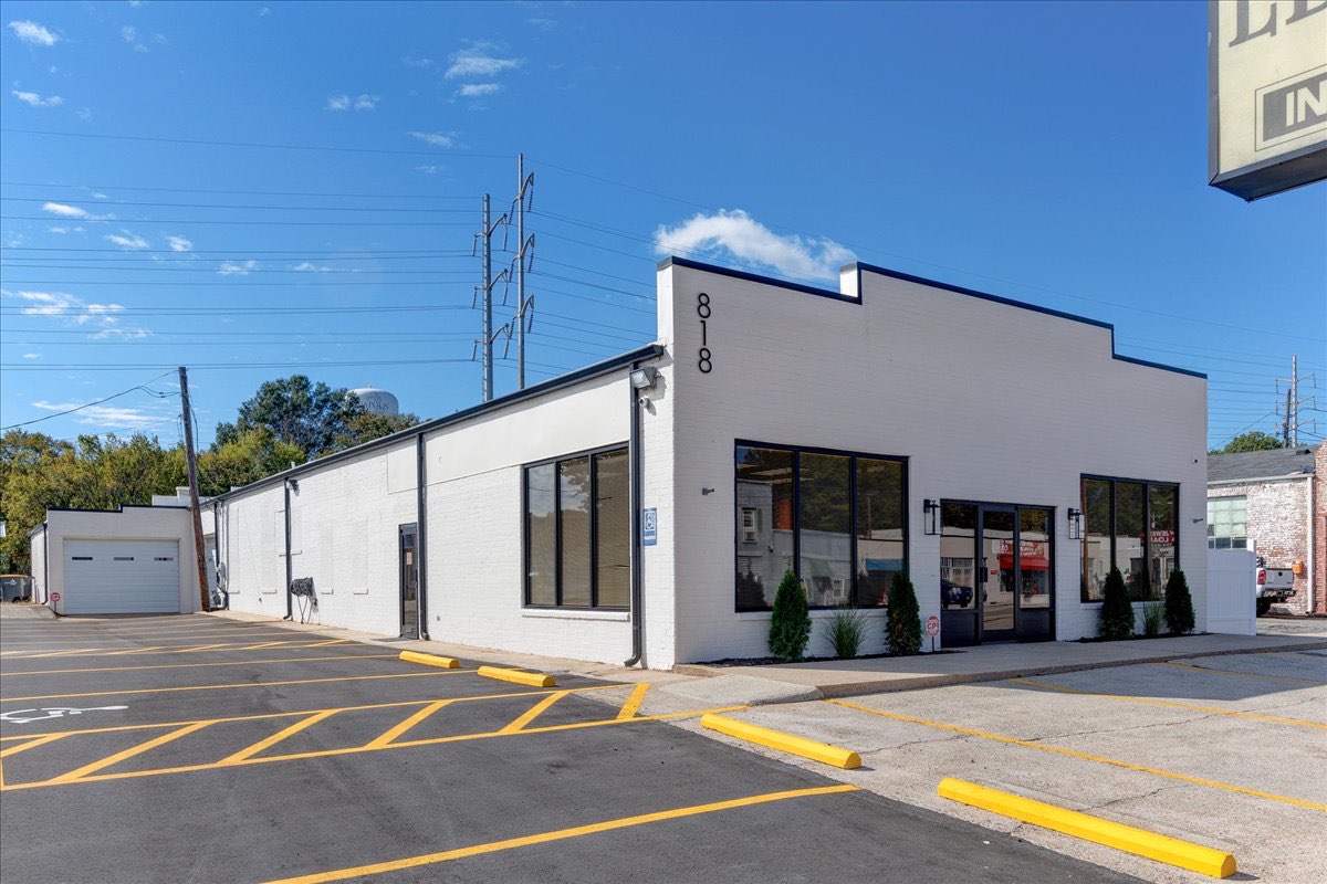 White brick exterior with black windows and doors of an office.