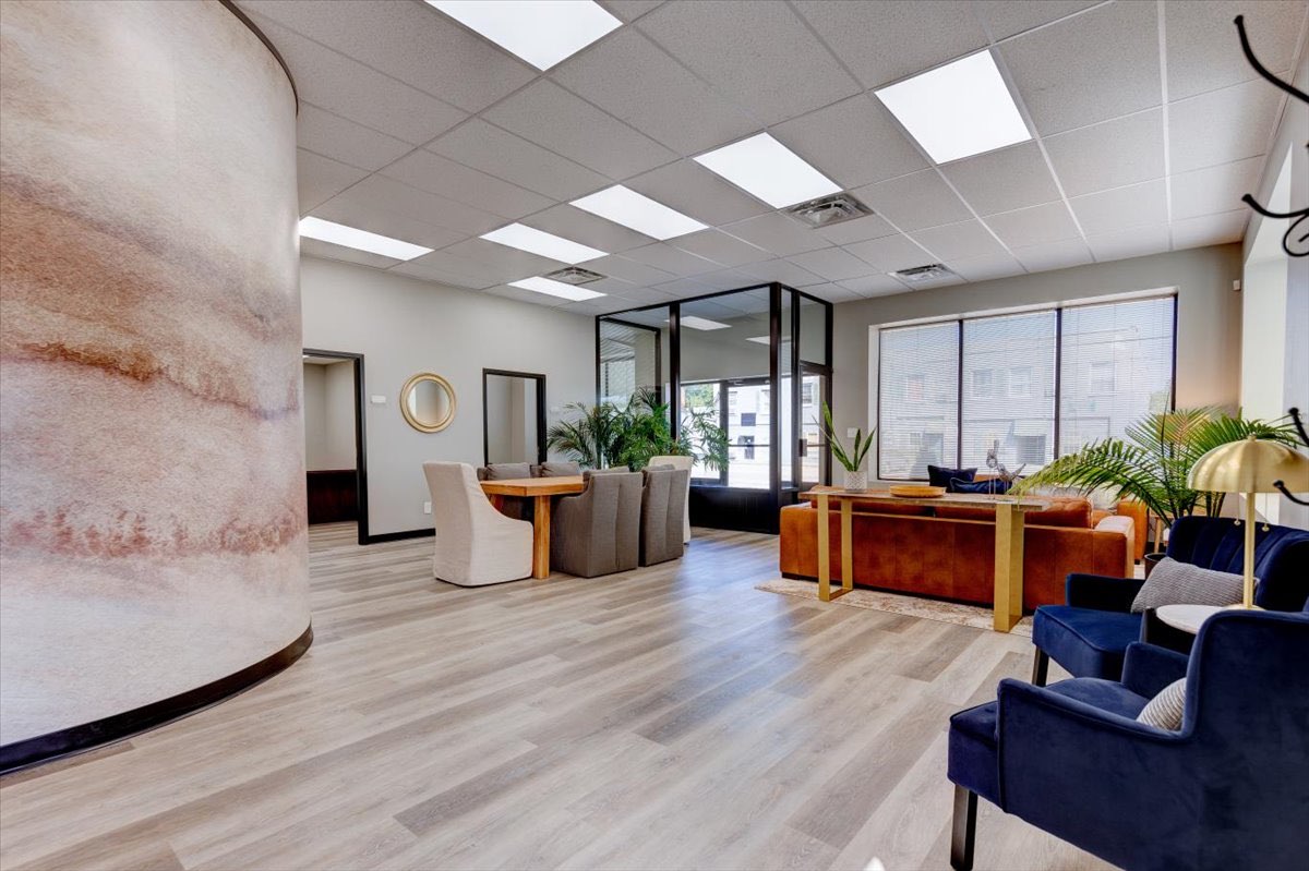 A modern waiting room with furniture and plants.