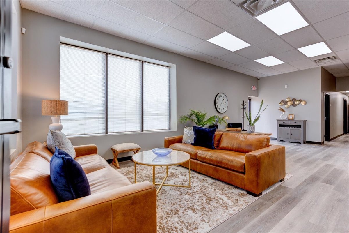 A waiting room interior with two orange leather couches.