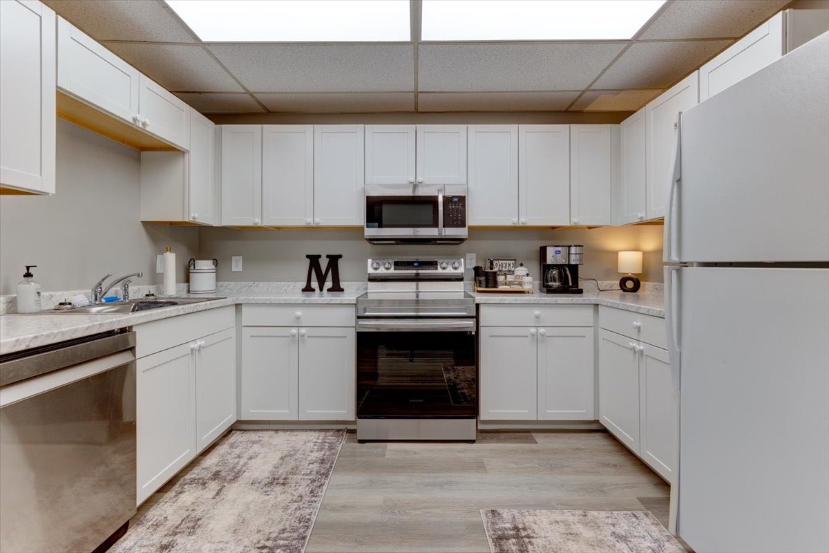 An office kitchenette with white cabinets.