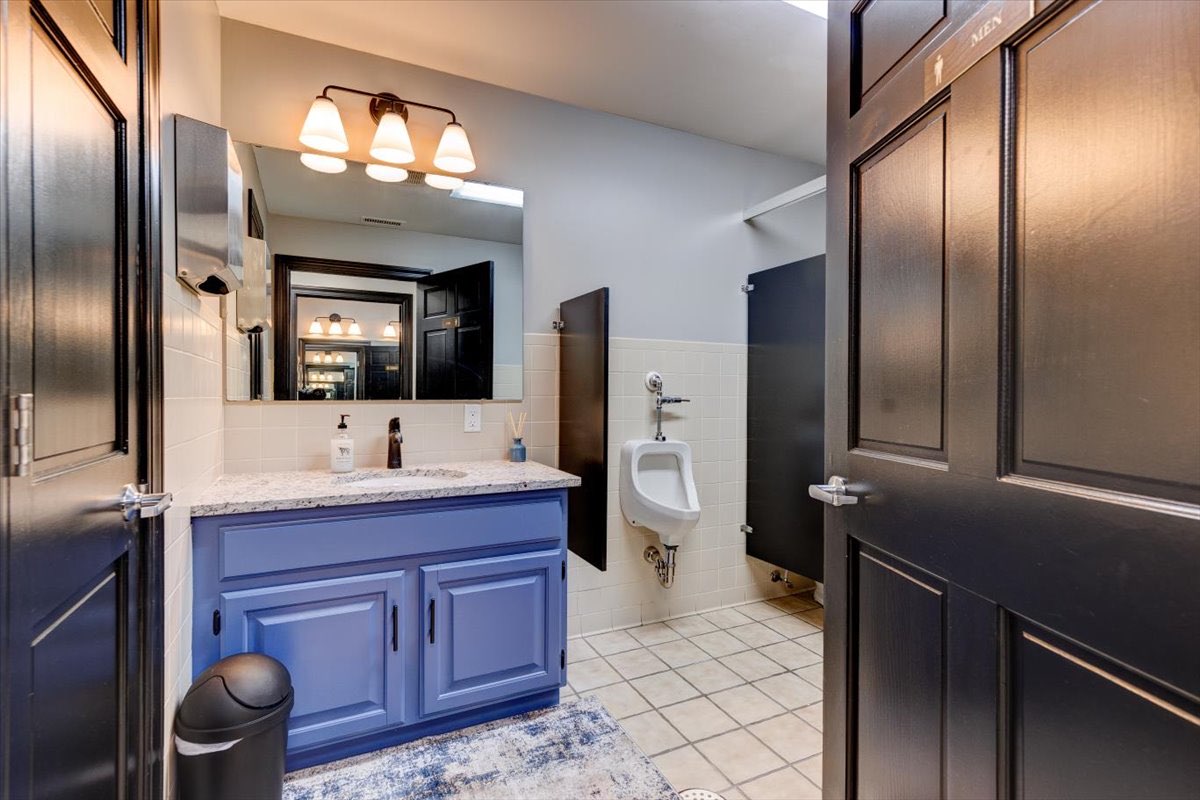 An office bathroom with a blue vanity.